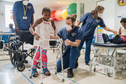 Declan-Osborne-Physical-Therapist-with-Fudia-orthopedics-patient-during-her-first-walking.jpg